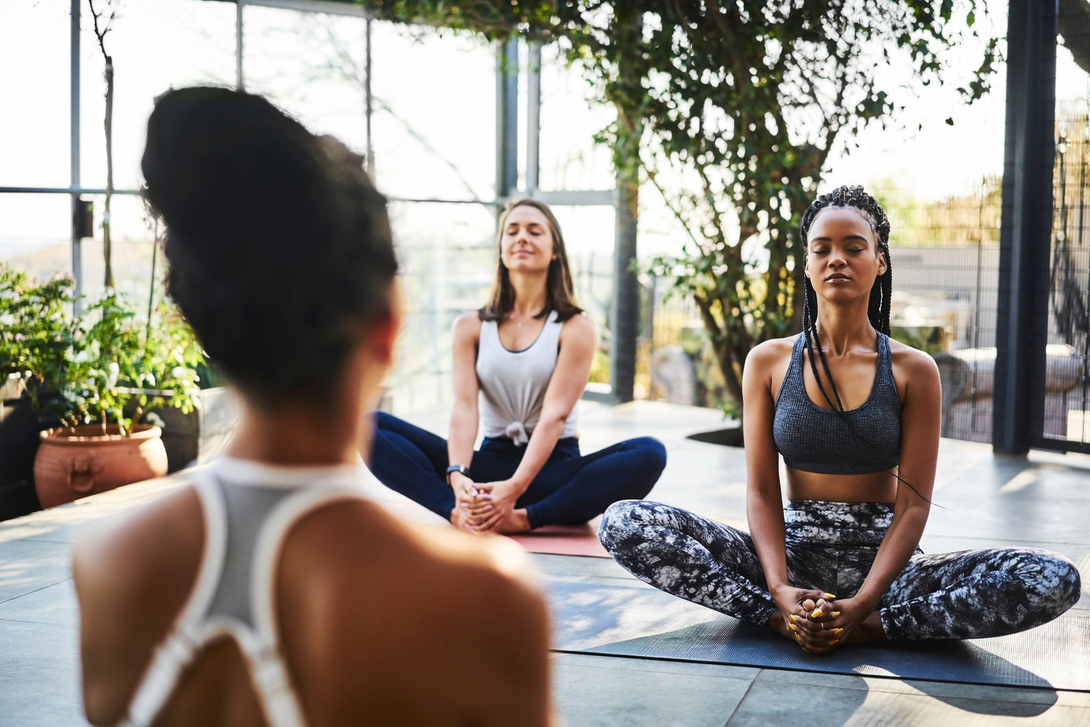 Women meditating with instructor during yoga class